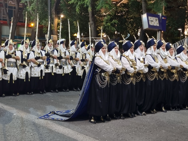 Moros y Cristianos de Murcia desfile nocturno con filas de guerreros en túnicas blancas y negras
