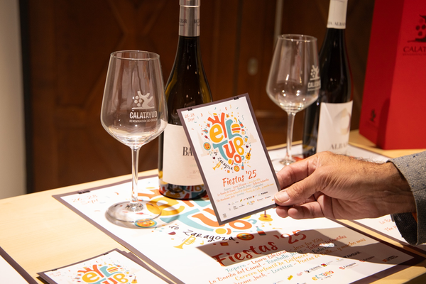 Cartel y copas de vino en las Fiestas del Tubo 2025 de Zaragoza