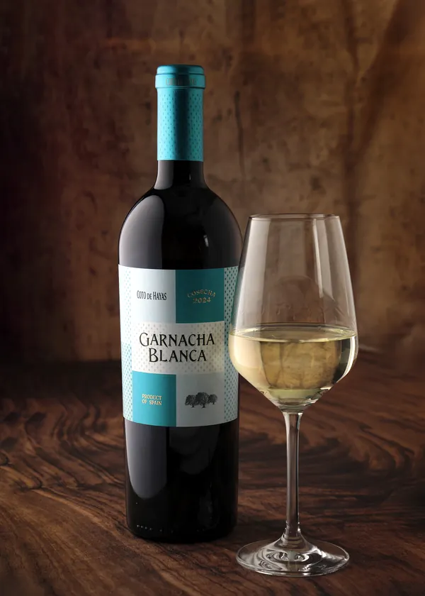 Coto de Hayas Garnacha Blanca, botella y copa en mesa de madera