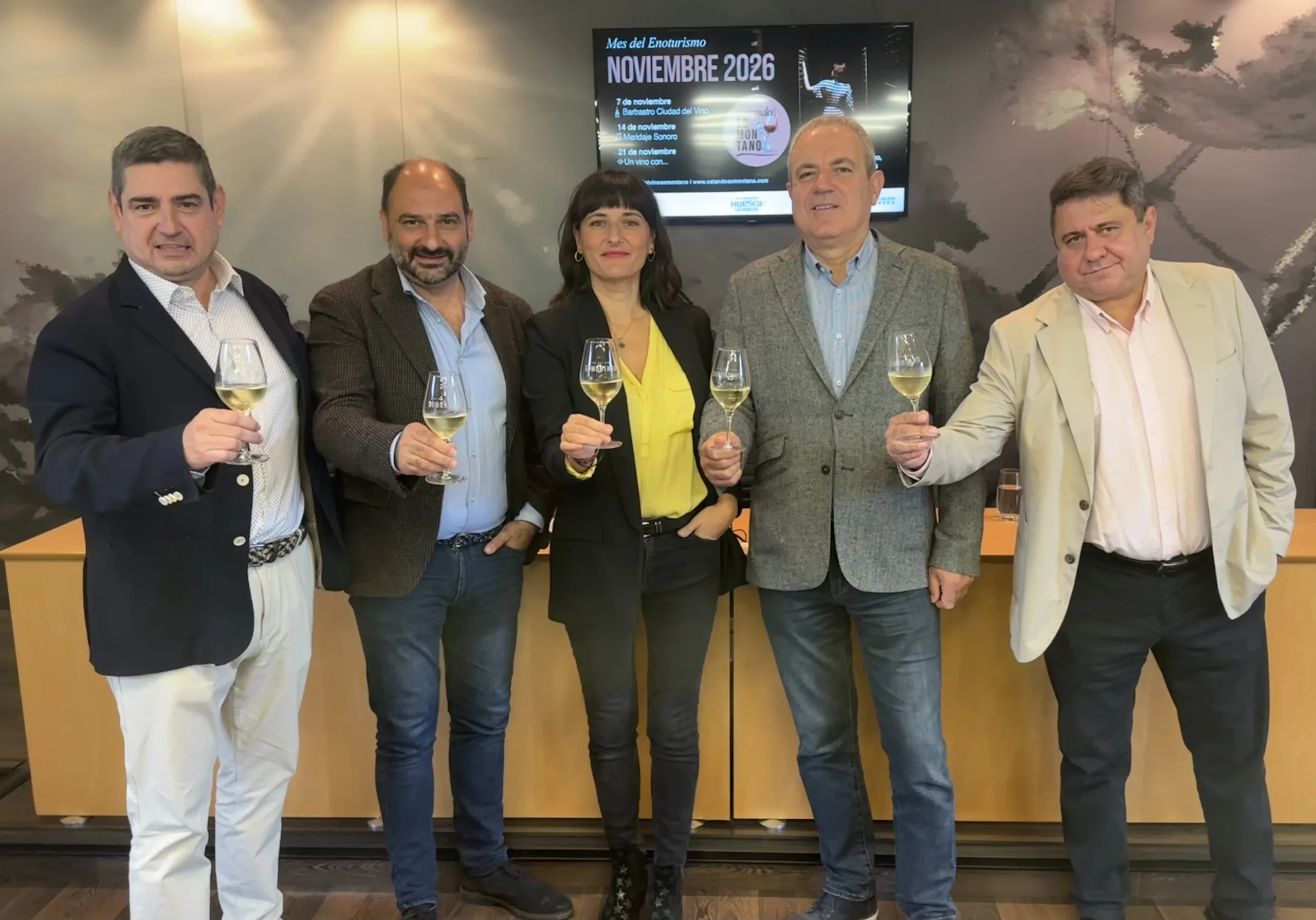 Cinco participantes en la presentación de CatandoSomontano 2026 brindan con copas de vino.