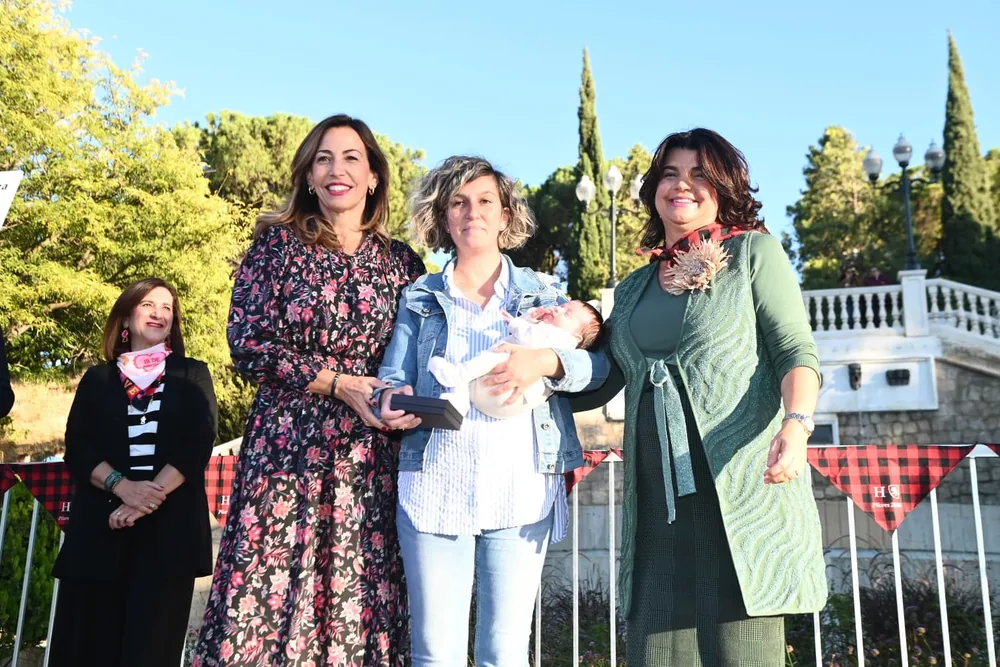 Una participante con un bebé recibe una caja durante el encuentro Mi primer cachirulo